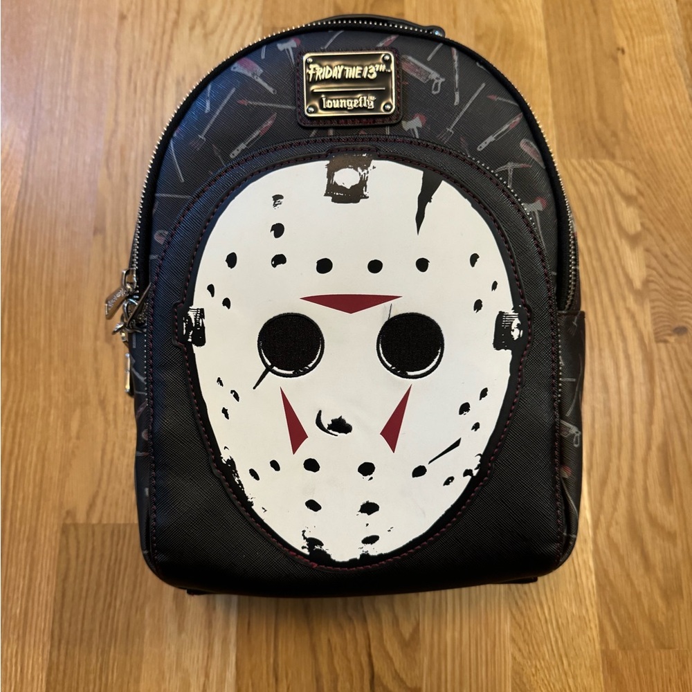 Loungefly: Friday the 13th: Jason Mask Mini Backpack glow in the dark mask.